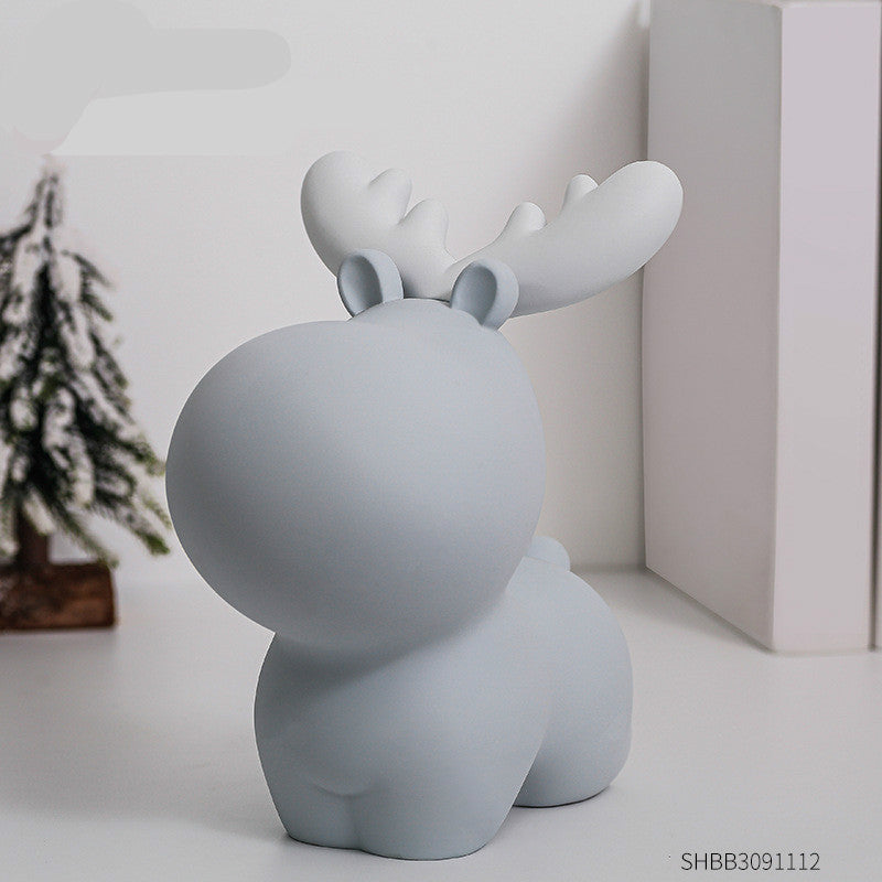Gray moose-shaped decorative item on a white surface with a blurred background. Piggy Bank.