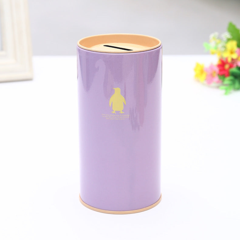 Purple cylindrical money box with a yellow lid on a white background.
Penguin on tinplate.