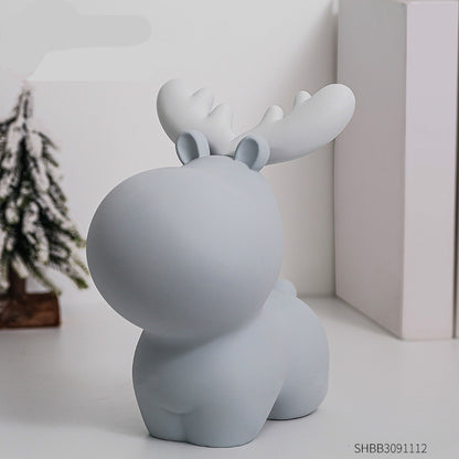Gray moose-shaped decorative item on a white surface with a blurred background. Piggy Bank.