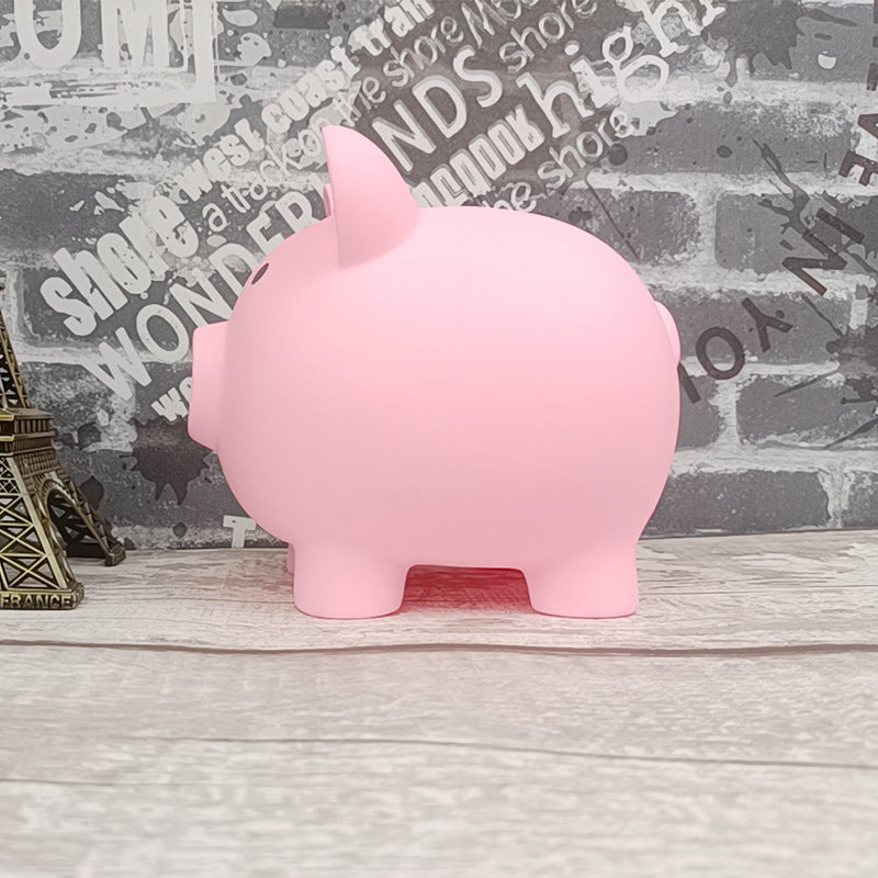 Pink piggy bank on a wooden surface with a newspaper background