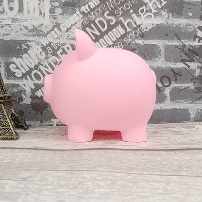 Pink piggy bank on a wooden surface with a newspaper background