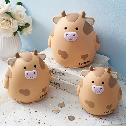 Three cute cow-shaped piggy banks on a surface with flowers in the background